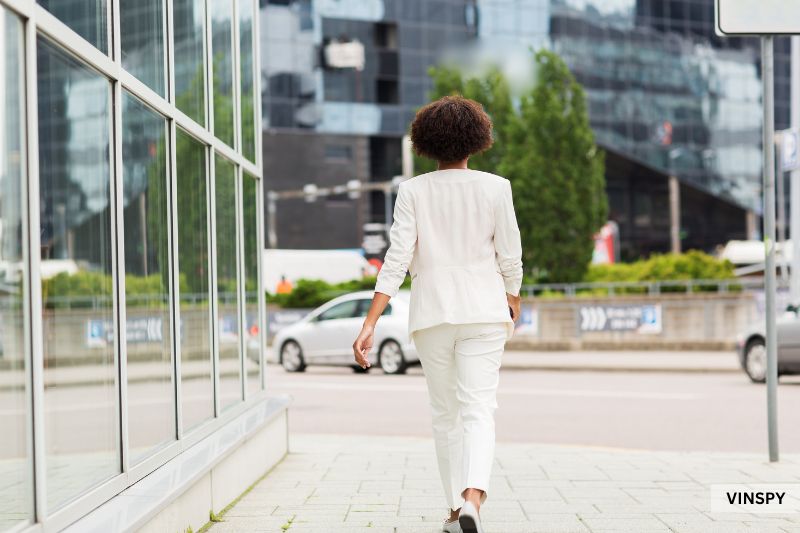 Woman walking near street traffic, reflecting on how to check if a car has been in an accident.